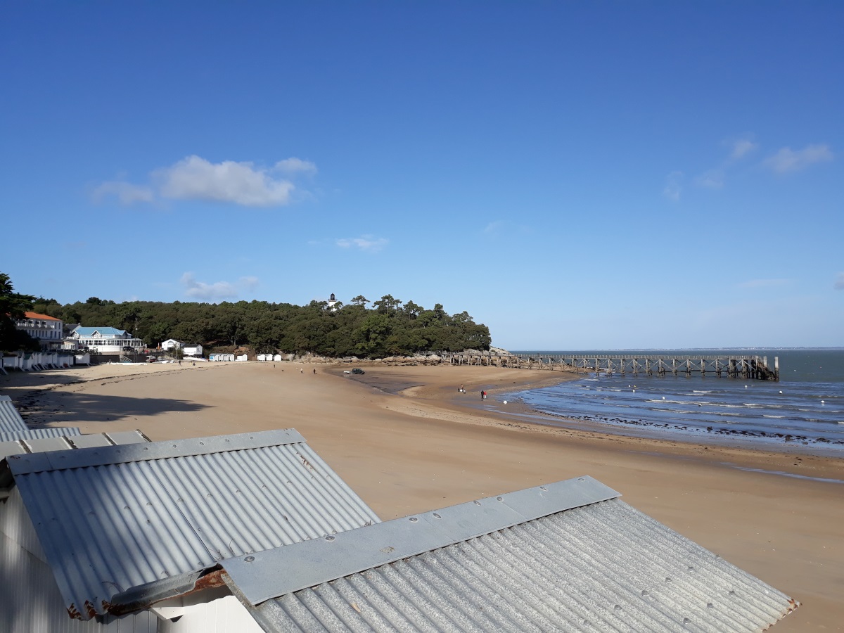 Strandhuisjes en het brede zandstrand van Plage des Dames bij laag water Strandhuisjes en het brede zandstrand van Plage des Dames bij laag water